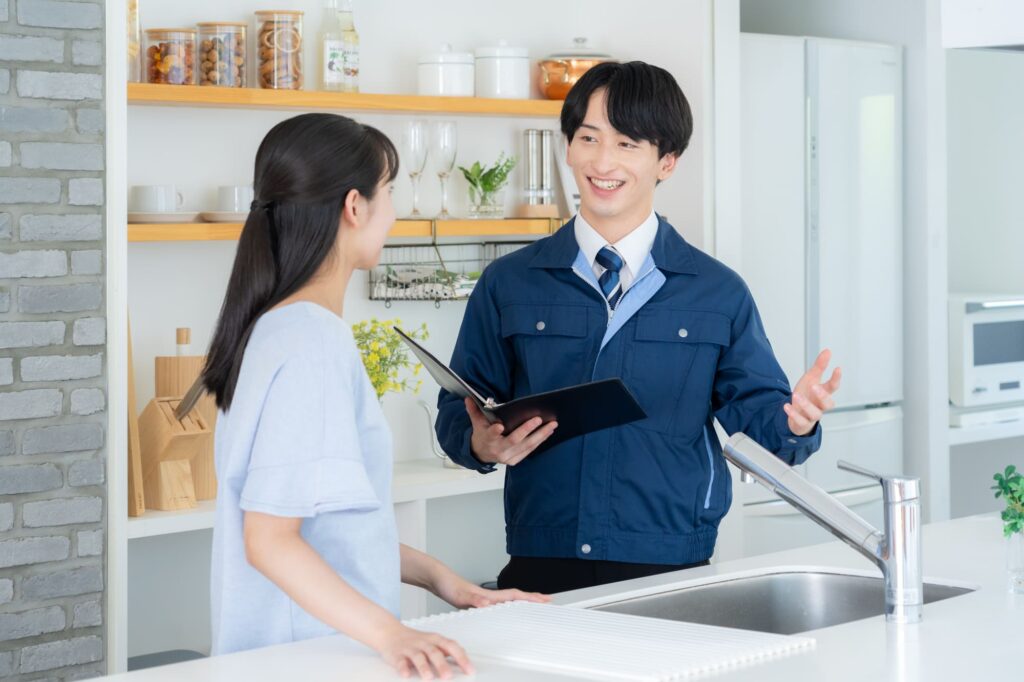 キッチンで女性に説明をするリフォーム業者