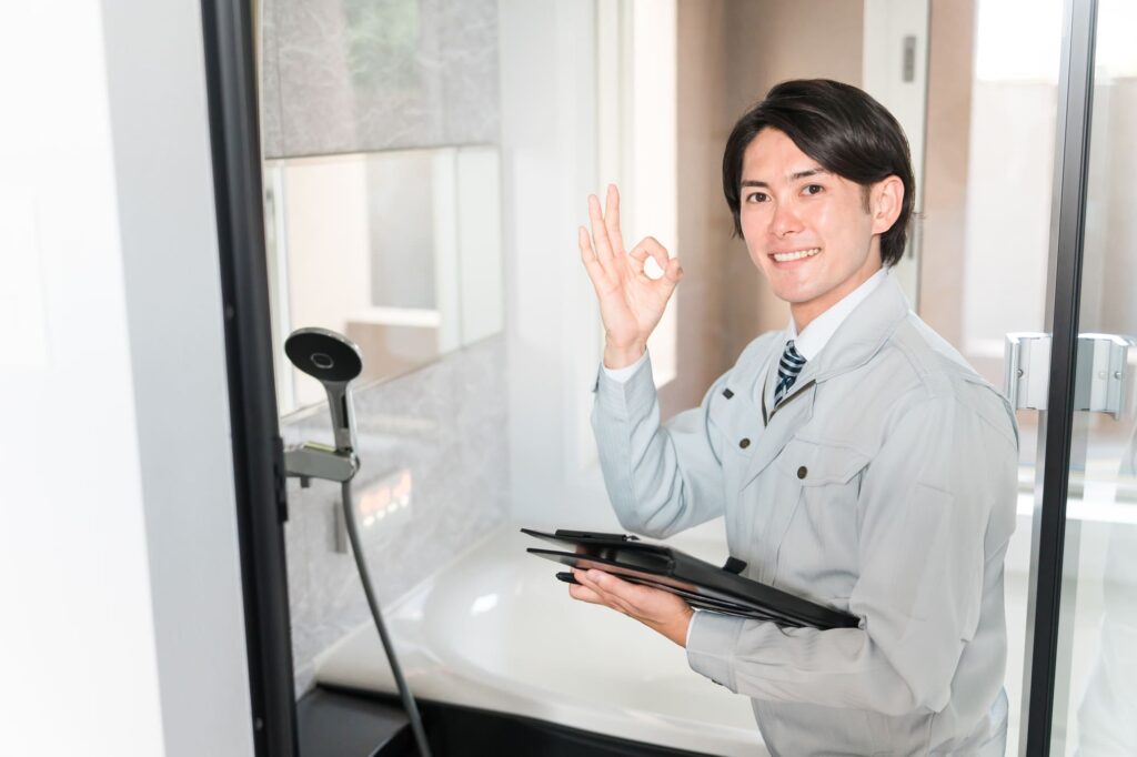 ユニットバスの前にいる作業着姿の若い男性ビジネスマン