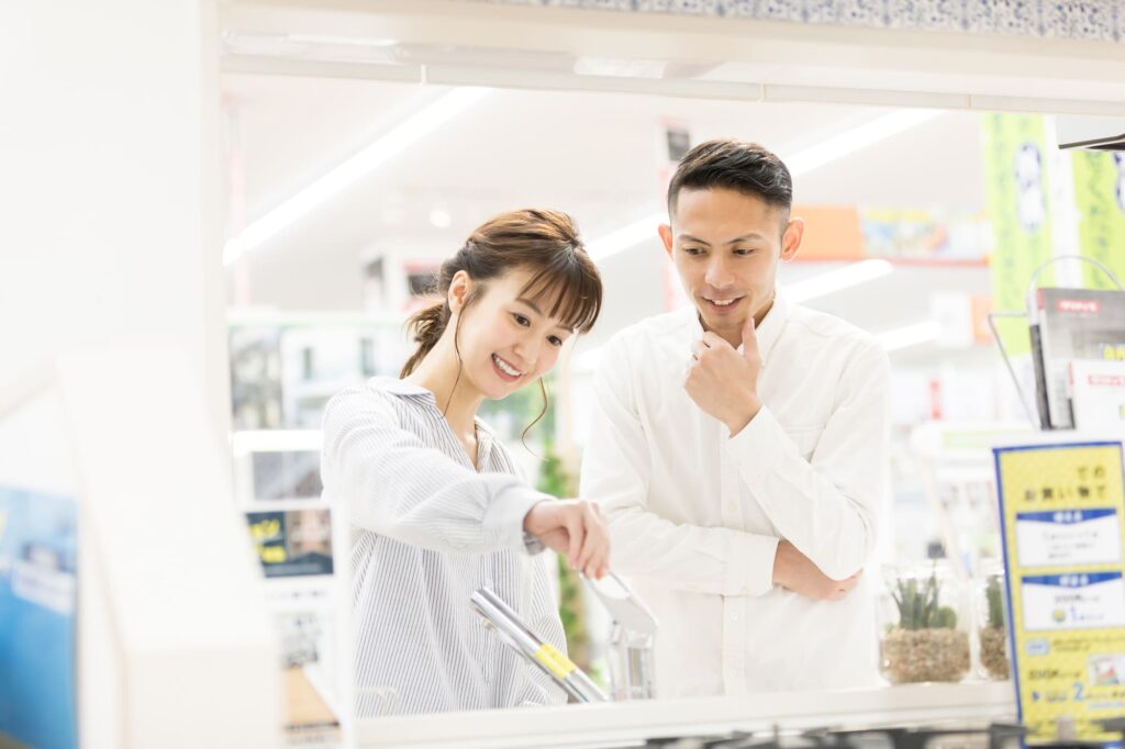 ホームセンター・家電量販店でキッチンを選ぶ若い夫婦